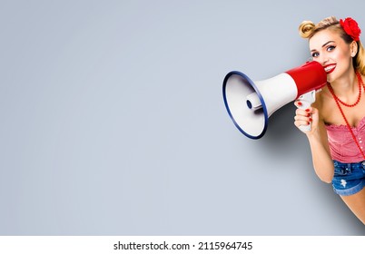 Beauty Blond Haired Woman Holding Mega Phone, Shout Something. Girl Dressed In Pin Up Style Wear With Megaphone Loudspeaker, Over Grey Background. Female Beauty Model In Retro Vintage Studio Concept.