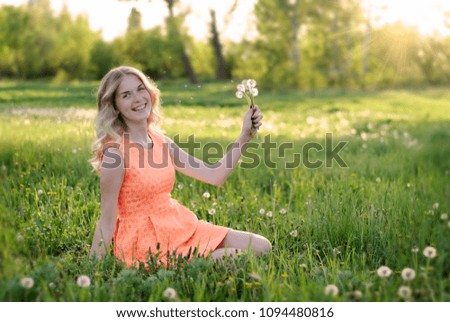Beauty blond model girl and smelling dandelion flowers. Allergy free. Healthy Smiling Girl portrait