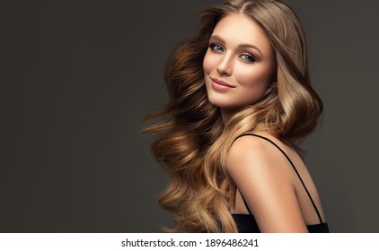 Beauty blonde girl with long  and   shiny wavy  hair .  Beautiful   woman model with curly hairstyle . Fashion, cosmetics and makeup - Shutterstock ID 1896486241