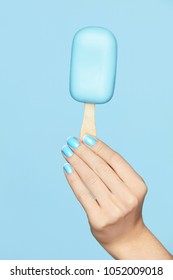 Beauty Blue Manicure. Woman Hand With Nails Art Holding Ice Cream On Blue Background. Close Up Of Female Hands With Fashion French Nails. Art Nail Design. High Quality Image.