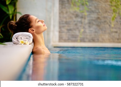 Beauty and body care. Sensual young woman relaxing in outdoor spa swimming pool.