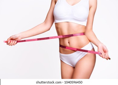 Beauty body care. Woman holding the meter with hands and measuring waist.