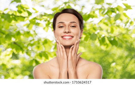 beauty, bodycare and people concept - beautiful young woman with bare shoulder over green natural background