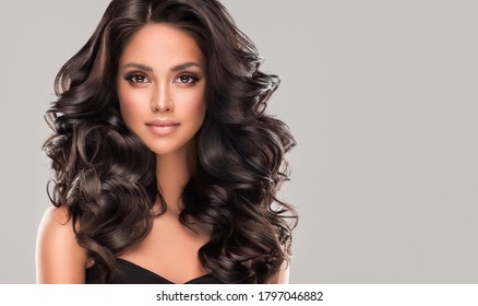 Beauty brunette girl with long  and   shiny wavy black hair .  Beautiful   woman model with curly hairstyle . - Shutterstock ID 1797046882
