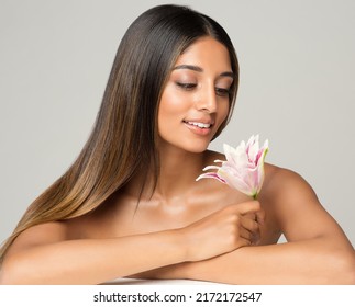 Beauty Brunette Model With Long Silk Shiny Hairstyle. Beautiful Woman Looking At Flower Relaxing In Spa Massage Salon. Women Face And Body Skin Care. Hair Cosmetology Over White Background