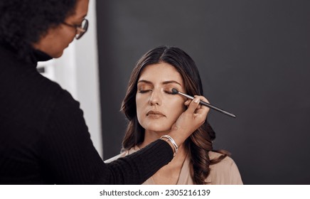 Beauty brush, makeup artist and woman with eyeshadow design, facial cosmetics service and studio skincare routine. Spa salon, cosmetology client or person apply face treatment, product or wellness - Powered by Shutterstock