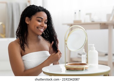 Beauty Care. Attractive Black Woman Wrapped In Towel Sitting At Dressing Table And Looking At Mirror, Smiling Young African American Female Making Selfcare Routine After Bath, Closeup Shot - Powered by Shutterstock