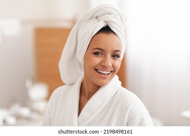 Beauty Care. Portrait Of Happy Woman Wearing White Bathrobe Posing With Wrapped Towel On Head During Selfcare Routine In Modern Bathroom At Home In The Morning. Spa And Wellness