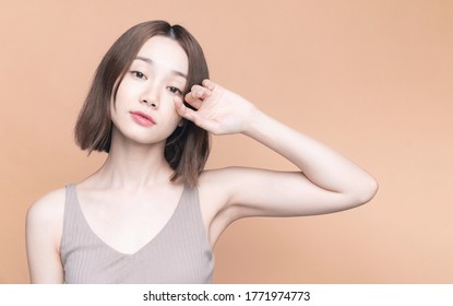 Beauty concept of an asian girl. Skin care. Cosmetics. Pale orange background.