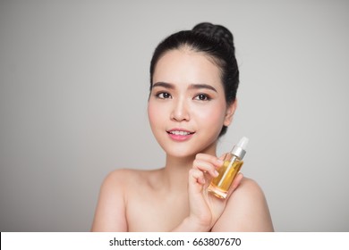 Beauty Concept. Asian Pretty Woman With Perfect Skin Holding Oil Bottle