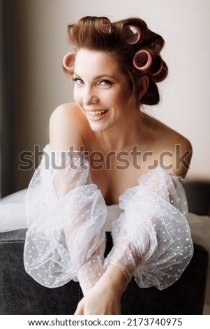 beauty concept. portrait of a beautiful young showy brunette woman with bright pin-up make-up in pink curlers. Studio Shot, Cropped. Facial treatment . Cosmetology , skin care and spa.