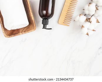 Beauty Cosmetic Bottle Container With Pump Mock Up, For Shampoo And Conditioner For Hair, Towel, Wooden Hair Comb On White Marble Background. Minimalist Cosmetic Product Mockup. Top View. 