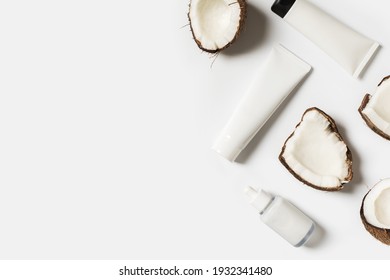 Beauty and cosmetic concept with serum bottles and coconut on white background, top view, flat lay