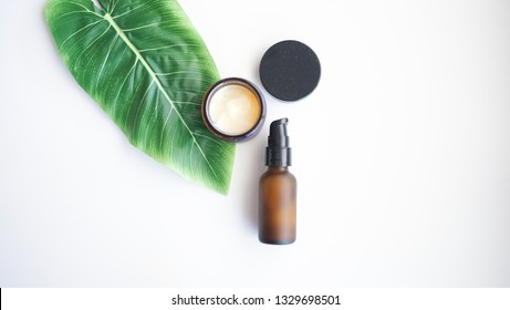 Beauty Cosmetic Skincare  Cream Serum Background .Products With Flower ,leaves On Table Top View, Flat Lay.minimal Modern.amber Bottle.