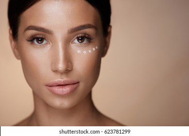 Beauty Cosmetics. Closeup Of Attractive Young Woman With Concealer Under Eyes. Portrait Of Beautiful Sexy Female Model With Fresh Clean Skin And Natural Makeup. Facial Make-up. High Resolution
