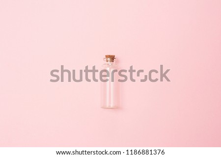 Beauty cosmetics glassbottle; branding mock up; top view on pastel pink background. Package for essential oil.