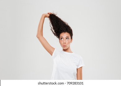 Beauty Curly Woman Pulling Up Her Hair Over Gray Background