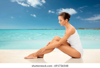 Beauty, Depilation, Epilation, People And Bodycare Concept - Beautiful Woman Touching Her Smooth Bare Legs Over Exotic Tropical Beach Background