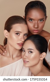 Beauty. Diverse Models Portrait. Tender Caucasian, Asian And Mixed Race Women Posing Together On Beige Background. Female With Perfect Skin And Natural Makeup Looking At Camera. 