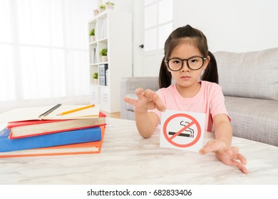 Beauty Elegant Girl Kid Showing No Smoking Sign To Camera When She Doing School Studying Homework In Living Room At Home.