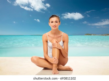 Beauty, Epilation, People And Bodycare Concept - Beautiful Woman Touching Her Smooth Bare Legs Over Exotic Tropical Beach Background