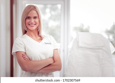 Beauty Expert. Beautiful Blonde-haired Beauty Expert Wearing White Uniform Smiling Broadly