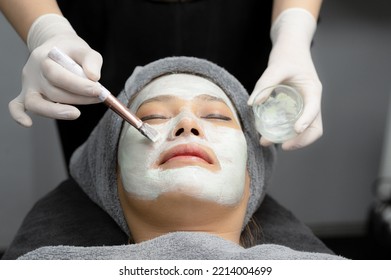 Beauty Expert Using Cream Mask For Young Woman In Beauty Clinic, Cream Mask, Beauty Care Clinic, Close-up Photo Focusing On Face.