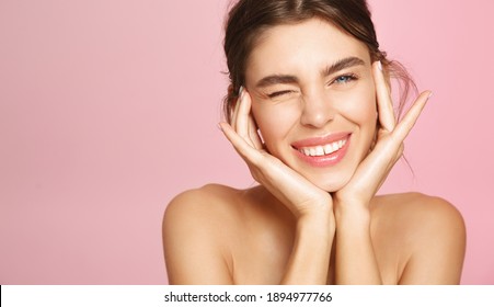 Beauty Face. Happy Young Woman Getting Ready For Romantic Valentines Day Date, Applying Makeup And Smiling. Pretty Girl Standing Naked, Nourish And Hydrate Skin On Pink Background.