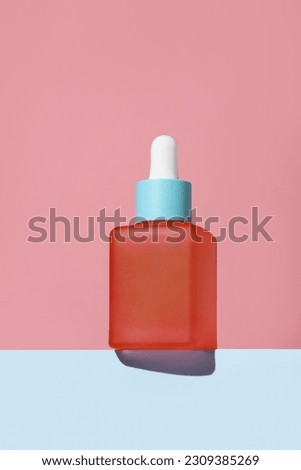 Beauty face serum in a glass dropper bottles on podium. skin care product. Colorful background and colored face serum. Facial skin care. Summer colors. Cosmetics shooting concept. Empty bottle. 