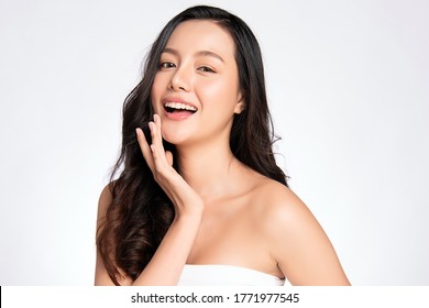 Beauty Face. Smiling Asian Woman Touching Healthy Skin Portrait. Beautiful Happy Girl Model With Fresh Glowing Hydrated Facial Skin And Natural Makeup On White Background,