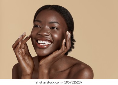 Beauty face. Smiling black woman touching healthy skin portrait. Beautiful girl with glowing skin and natural makeup`. Skin care concept