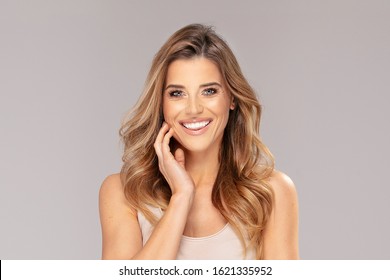 Beauty face of the young beautiful smiling woman. Closeup portrait of an attractive caucasian female. Makeup and hairstyle concept. Beauty treatment.