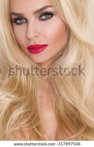 Beauty face of the young beautiful woman - isolated on white background. Gorgeous female portrait with slicked blond hair. Young adult girl with healthy skin. Pretty lady with fashion eye makeup.