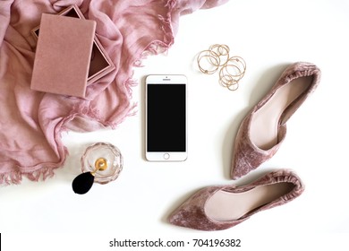 Beauty & fashion blog concept. Stylish feminine accessories flatlay isolated on white background. Minimal flat lay top view. Woman pink scarf, jewellery, velvet shoes, perfume, smartphone mockup