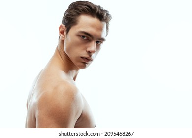 Beauty and fashion. Close-up portrait of young handsome man isolated on white studio background. Concept of men's health, self-care, body and skin care. Male model looking at camera