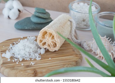 Beauty And Fashion Concept With Spa Setting. Composition With Dead Sea Salt, Luffa,  Natural Cosmetic Scrab,  Soda, Sea Loofah. Flat Lay, Spa Concept With Cotton Flower, Stones And Towel.