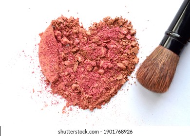 Beauty Fashion Creativity Concept Photo Of Heart Shape Of Broken Blush Color Cosmetic Powder And Makeup Brush Kit On White Background.