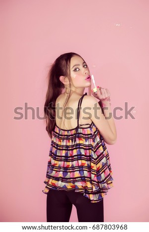 Beauty and fashion. Girl with glamour makeup and hair. Bubble blower in hand of fashion model. Woman play with soap balloon. Fun and joy.