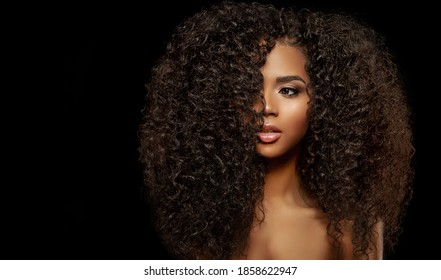 Modelo de moda de beleza. Rosto de mulher negra e lindos cabelos volumosos. Garota afro-americana. Rosto feminino de pele de beleza. 
Cabelo saudável com luxuoso corte de cabelo Updo. Ondas, volume de cachos Penteado. Salão de cabeleireiro.