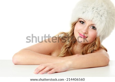 Beauty fashion model girl in a fur hat.Isolated on white