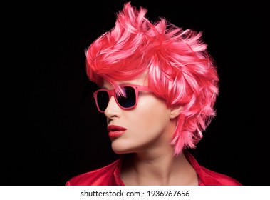 Beauty Fashion Model Girl With Stylish Red Pink Hair Wearing Modern Sunglasses. Profile Closeup Portrait Isolated On Black