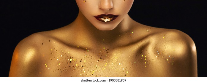 beauty fashion model girl's mouth close-up. Golden body skin. Glamour golden bright lipstick closeup. Liquid gold metal dripping from red lips. Beautiful artistic makeup shiny paint drop on woman face