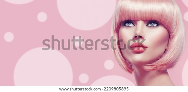 Beauty Fashion Model Portrait pink hair color.\
Bob Short Haircut. Fringe Hairstyle. Hairdressing. Beautiful\
Glamour Girl with Short blonde hair. Dyed hair, perfect makeup.\
Over pink background