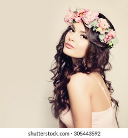 Beauty Fashion Portrait. Beautiful Woman with Curly Hair, Makeup and Flowers Wreath