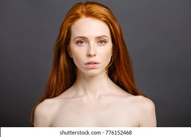 Beauty fashion portrait of nude redhead woman with perfect skin. attractive sexy girl with shiny hair on grey background