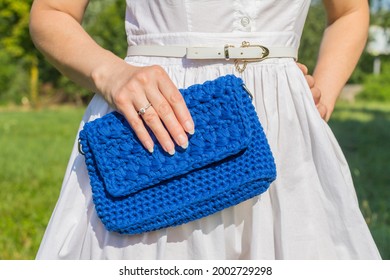 Beauty And Fashion. Stylish Fashionable Woman Holding Knitted Clutch Bag On Nature Background 