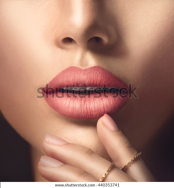 Beauty Fashion woman sexy lips with natural\
Makeup and beige Nail polish. Matte lipstick and nails. Beauty girl\
face close up. Nude Colors. Manicure, Make up. Plastic surgery-\
injections or fillers