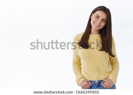 Beauty, fashion and women concept. Gorgeous brunette girl in yellow sweater tilt head and smiling as listening to person interesting story, have friendly casual conversation, white background