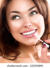 Beauty Girl Applying Lipgloss. Makeup. Beautiful Woman's Face. Apply Make-up. Healthy Smile. White Teeth.