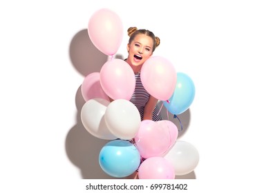 Beauty girl with colorful air balloons laughing, isolated on white background. Beautiful Happy Young woman on birthday holiday party. Joyful model having fun and celebrating with pastel color balloon.